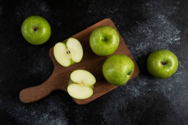 Tahta tahtada tam ve dilimlenmiş olgun yeşil elmalar. Yüksek kalite fotoğraf