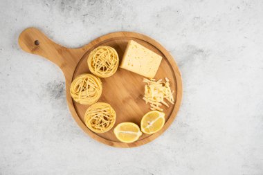 Pişmemiş spagetti yuvaları, limon ve peynir ahşap tahtalar. Yüksek kalite fotoğraf