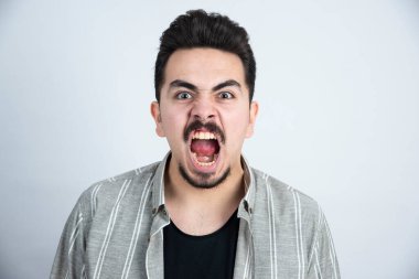 Sıradan giyinmiş, dikilip bakan genç bir adamın portresi. Yüksek kalite fotoğraf