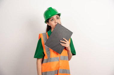 Miğferi ve panosu olan genç bir işçi kadın. Yüksek kalite fotoğraf