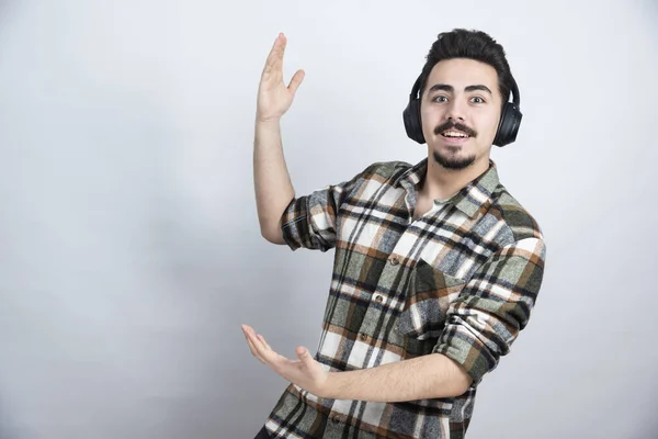 Photo of handsome guy in headphones singing a song and dancing. High quality photo