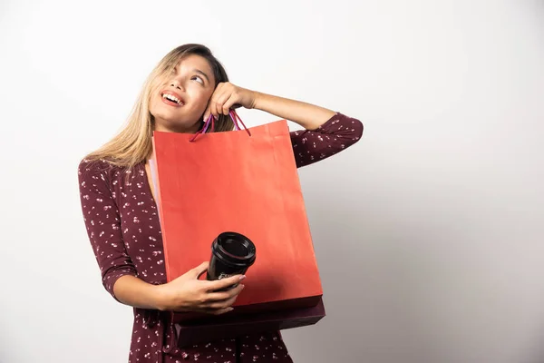 Jonge Vrouw Met Winkeltassen Een Kop Drank Een Witte Achtergrond — Stockfoto