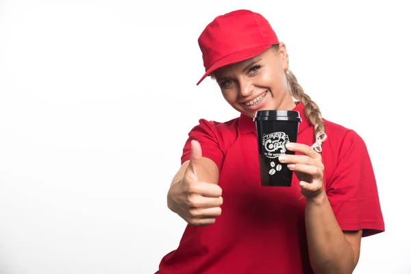 笑顔女性で赤制服保持1カップのコーヒー上の白い背景 — ストック写真
