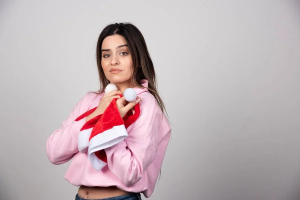 Uma Jovem Segurando Chapéus Papai Noel Posando Foto Alta Qualidade — Fotografia de Stock