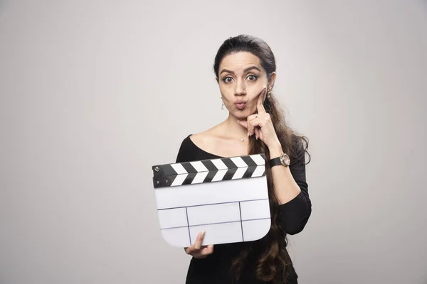 Uma Garota Cineasta Segurando Uma Tábua Aberta Parecendo Confusa Pensando — Fotografia de Stock