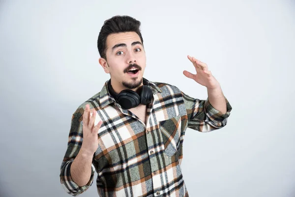 Foto Homem Bonito Com Fones Ouvido Olhando Sobre Parede Branca — Fotografia de Stock