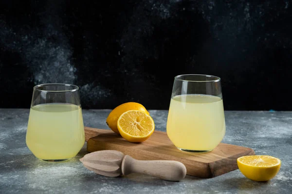 新鮮なレモンジュースと木製のリーマーの2つのガラスカップ 高品質の写真 — ストック写真