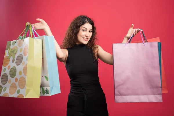 Mujer Feliz Con Muchas Bolsas Sobre Fondo Rojo —  Fotos de Stock