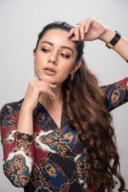 Gri arka planda duran gözleri kapalı genç bir kadın. Yüksek kalite fotoğraf