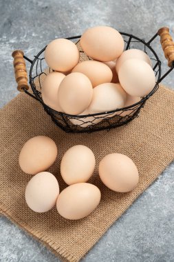 Mermer zemin üzerinde çiğ organik yumurta sepeti. Yüksek kalite fotoğraf