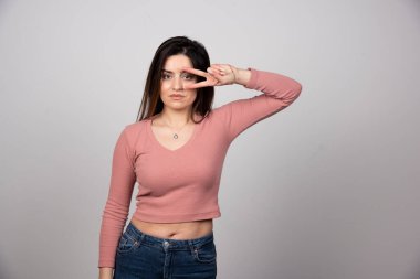 Barış elini gösteren genç bir kadın göz ucuyla şarkı söylüyor. Yüksek kalite fotoğraf