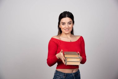 Elinde bir yığın kitap tutan gülümseyen bir kadının portresi. Yüksek kalite fotoğraf