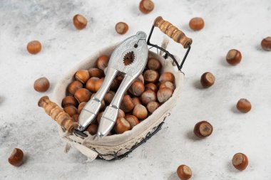 Bir sepet kabuklu fındık ve mermer arka planda fındık kırma aleti. Yüksek kalite fotoğraf
