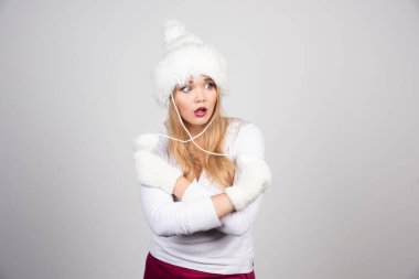 Gri arka planda poz veren kışlık kıyafetli güzel bir kadın. Yüksek kalite fotoğraf