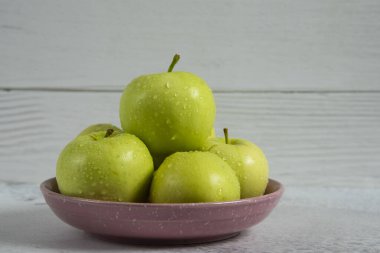 Beyaz tabakta yeşil elmalar