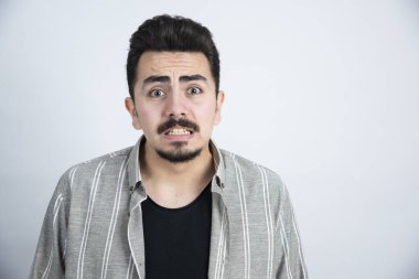 Sıradan giyinmiş, dikilip bakan genç bir adamın portresi. Yüksek kalite fotoğraf