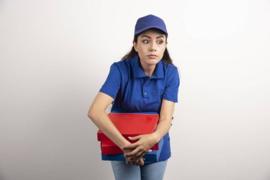 Elinde bir sürü pizza ve dosya olan genç bir kurye. 