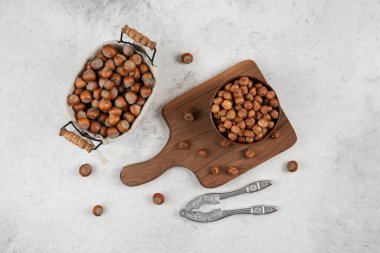 Bir sepet kabuklu fındık, çekirdek ve fındık kırma aleti kesme tahtasının yanında. Yüksek kalite fotoğraf