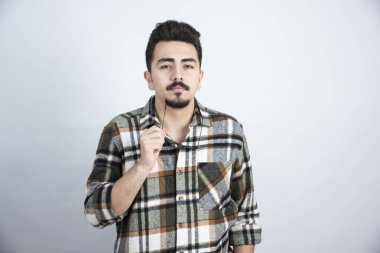 Gözlüklü, beyaz duvarın üzerinde duran yakışıklı sakallı adamın portresi. Yüksek kalite fotoğraf