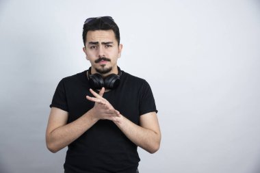 Esmer adam, beyaz duvara karşı kulaklık takıyor. Yüksek kalite fotoğraf