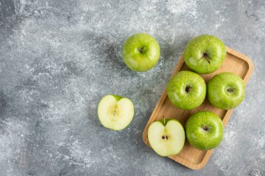 Tahta tabakta bir sürü bütün ve dilimlenmiş yeşil elma. Yüksek kalite fotoğraf