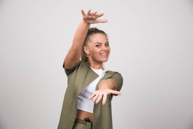 Beyaz gömlekli genç ve güzel bir kadın açık alan gösteriyor. Yüksek kalite fotoğraf