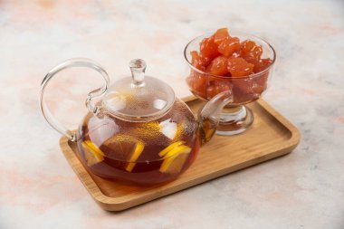 Çaydanlık dolusu siyah çay ve ahşap tabakta tatlı ayva reçeli. Yüksek kalite fotoğraf