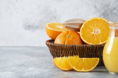 Taştan arka planda sulu portakal meyveleriyle dolu bir hasır kutu. Yüksek kalite fotoğraf