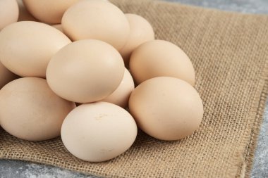 Mermer yüzeyinde masa örtüsü olan pişmemiş organik yumurta yığını. Yüksek kalite fotoğraf