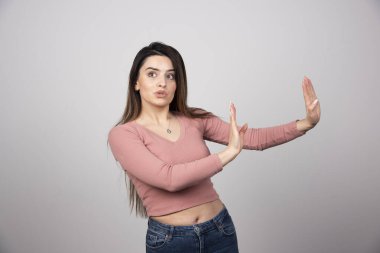 Gündelik giysiler giyen genç bir kadın negatif işaretler yapıyor. Yüksek kalite fotoğraf