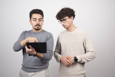 Kalemle defter gösteren iki genç adam. Yüksek kalite fotoğraf