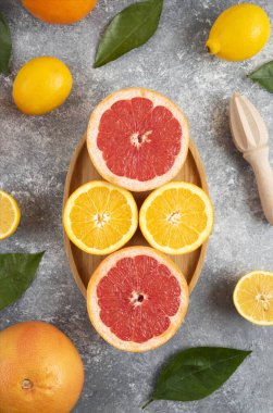 Gri arka planda tahtadan yapılmış organik narenciye meyvelerinin üst görüntüsü. Yüksek kalite fotoğraf