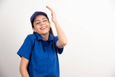 Mavi üniformalı güzel bir kadın elleriyle yüzüne dokunuyor. Yüksek kalite fotoğraf