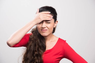 Alnına el ele tutuşan kırmızı elbiseli üzgün kadının portresi. Yüksek kalite fotoğraf