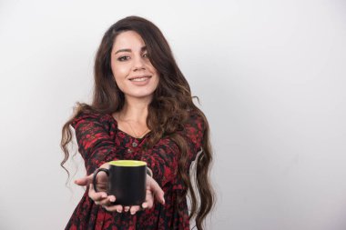 Gri arka planda boş bardak sunan uzun saçlı kadın. Yüksek kalite fotoğraf