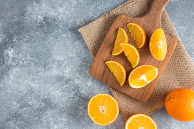 Taş zemin üzerinde portakal suyu dilimleriyle dolu tahta bir tahta. Yüksek kalite fotoğraf