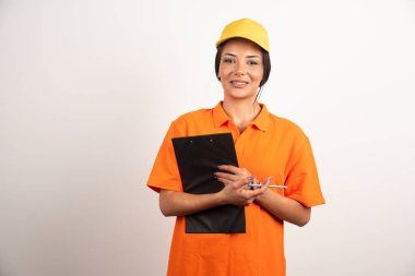 Beyaz arka planda kalem ve not panosu olan gülümseyen kadın kurye. Yüksek kalite fotoğraf