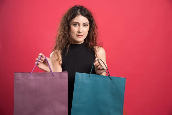 Mujer Feliz Con Muchas Bolsas Sobre Fondo Rojo —  Fotos de Stock