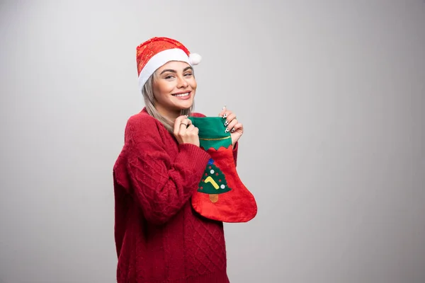 サンタの帽子の女性はクリスマスのストッキングを保持する 高品質の写真 — ストック写真