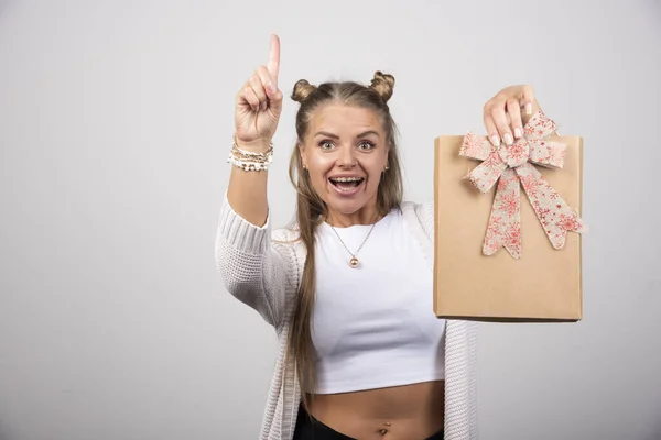 Glada Kvinna Visar Gåva Och Pekar Uppsidan Högkvalitativt Foto — Stockfoto