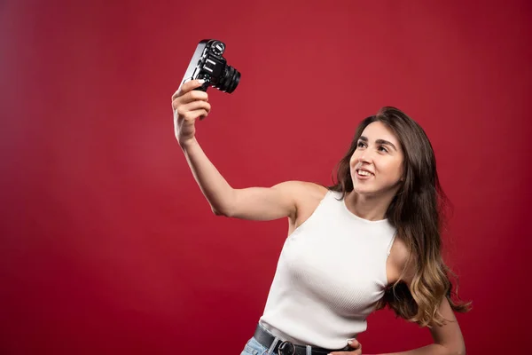 Ładna Kobieta Robi Selfie Kamerą Czerwonym Tle Wysokiej Jakości Zdjęcie — Zdjęcie stockowe