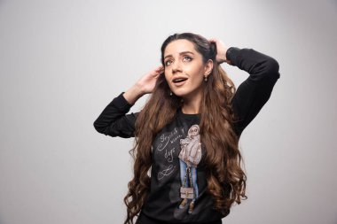 Gri arka planda mutlu poz veren sevimli genç kız. Yüksek kalite fotoğraf