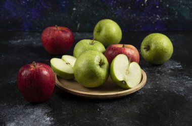 Tam ve dilimlenmiş yeşil ve ahşap tabakta kırmızı elmalar. Yüksek kalite fotoğraf