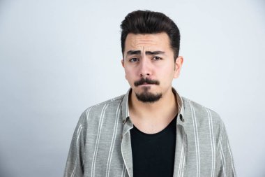 Sıradan giyinmiş, dikilip bakan genç bir adamın portresi. Yüksek kalite fotoğraf