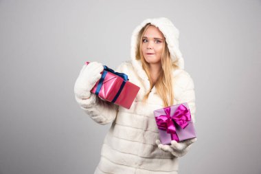 Sarışın kadın mutlu bir şekilde hediye kutuları gösteriyor. Yüksek kalite fotoğraf