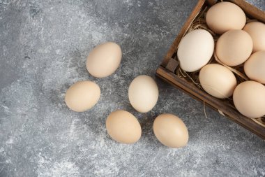 Mermer yüzeyde organik çiğ yumurta dolu ahşap kutu. Yüksek kalite fotoğraf