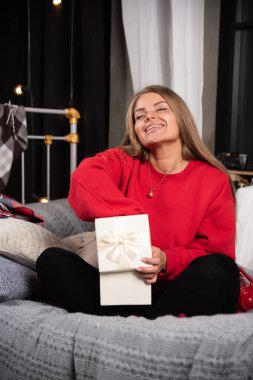 Hediye kutusundan bir şey alan genç bir kadının portresi. Yüksek kalite fotoğraf