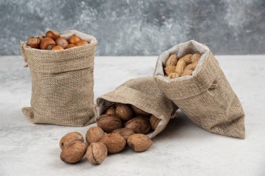 Organik kabuklu fındık, fıstık ve ceviz mermer arka planda çuval bezde. Yüksek kalite fotoğraf