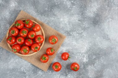Mermer zemin üzerinde tahtadan taze organik domates tabağı. Yüksek kalite fotoğraf