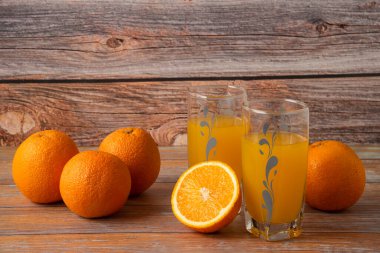 Cam bardakta portakal suyu ve ahşap masada dilimlenmiş meyve suyu. Yüksek kalite fotoğraf